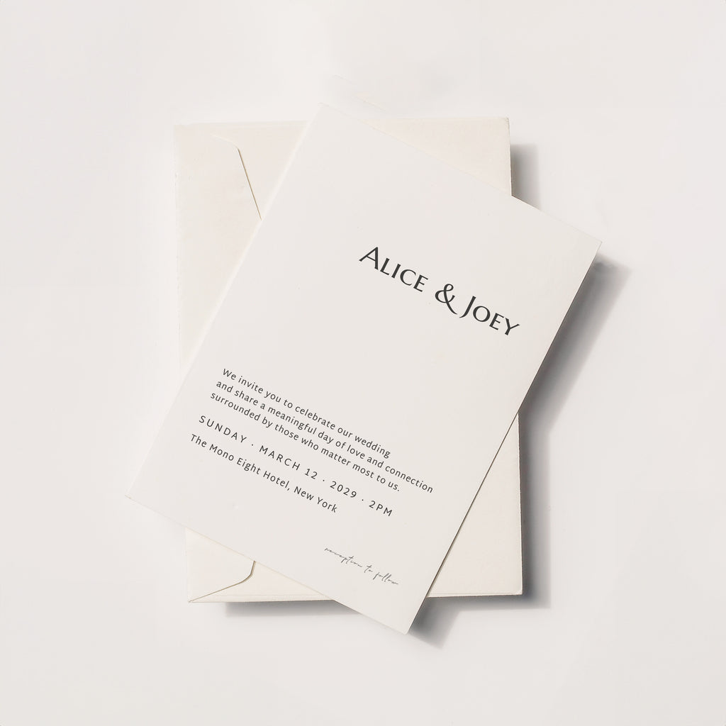 Minimalist wedding invitation card with serif typography, Alice & Joey names on ivory paper with envelope, modern elegant flat lay