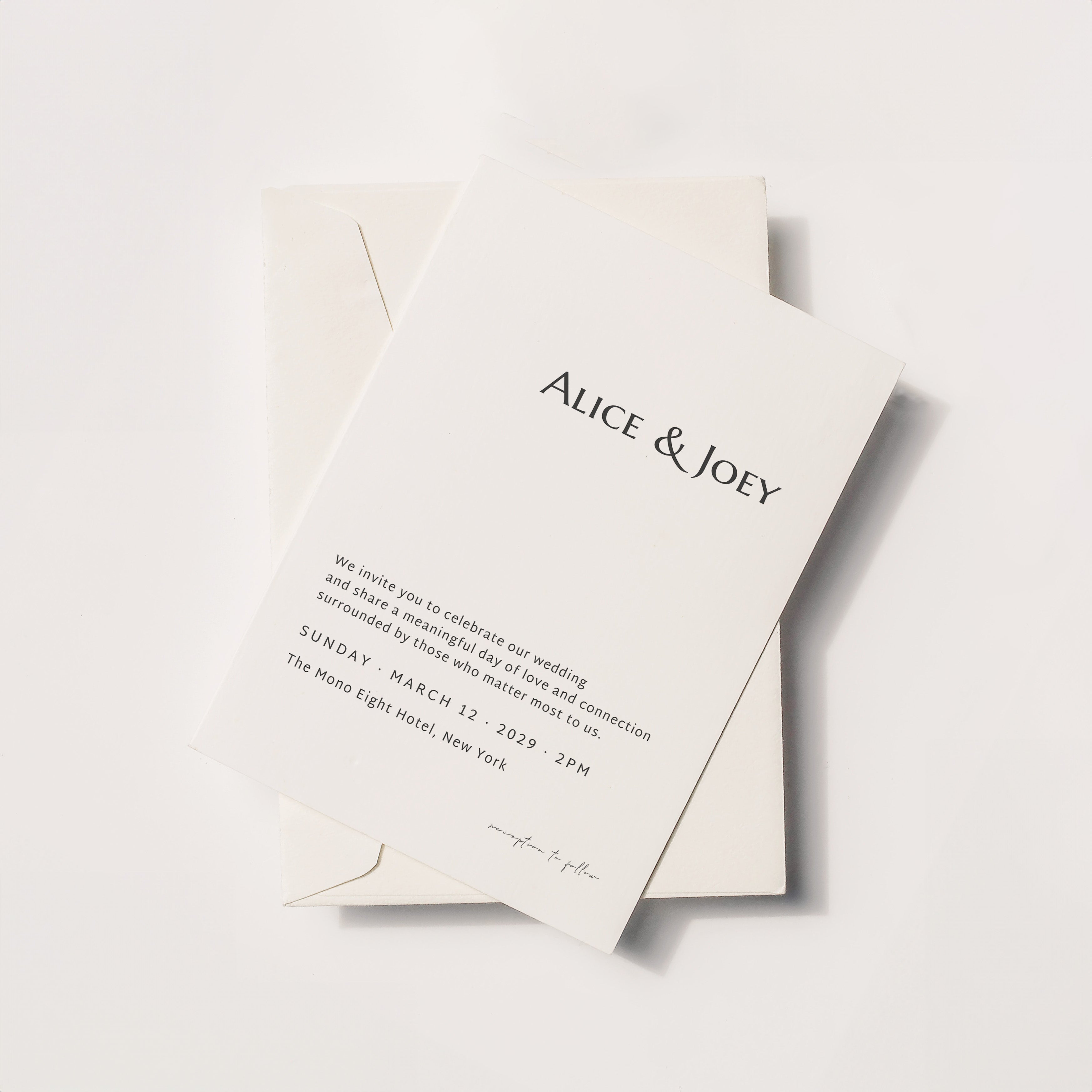 Minimalist wedding invitation card with serif typography, Alice & Joey names on ivory paper with envelope, modern elegant flat lay