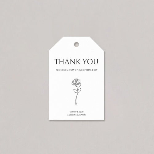 Elegant wedding favor tag with clean serif typography, a simple floral line detail, and a smooth white cord on a light background.