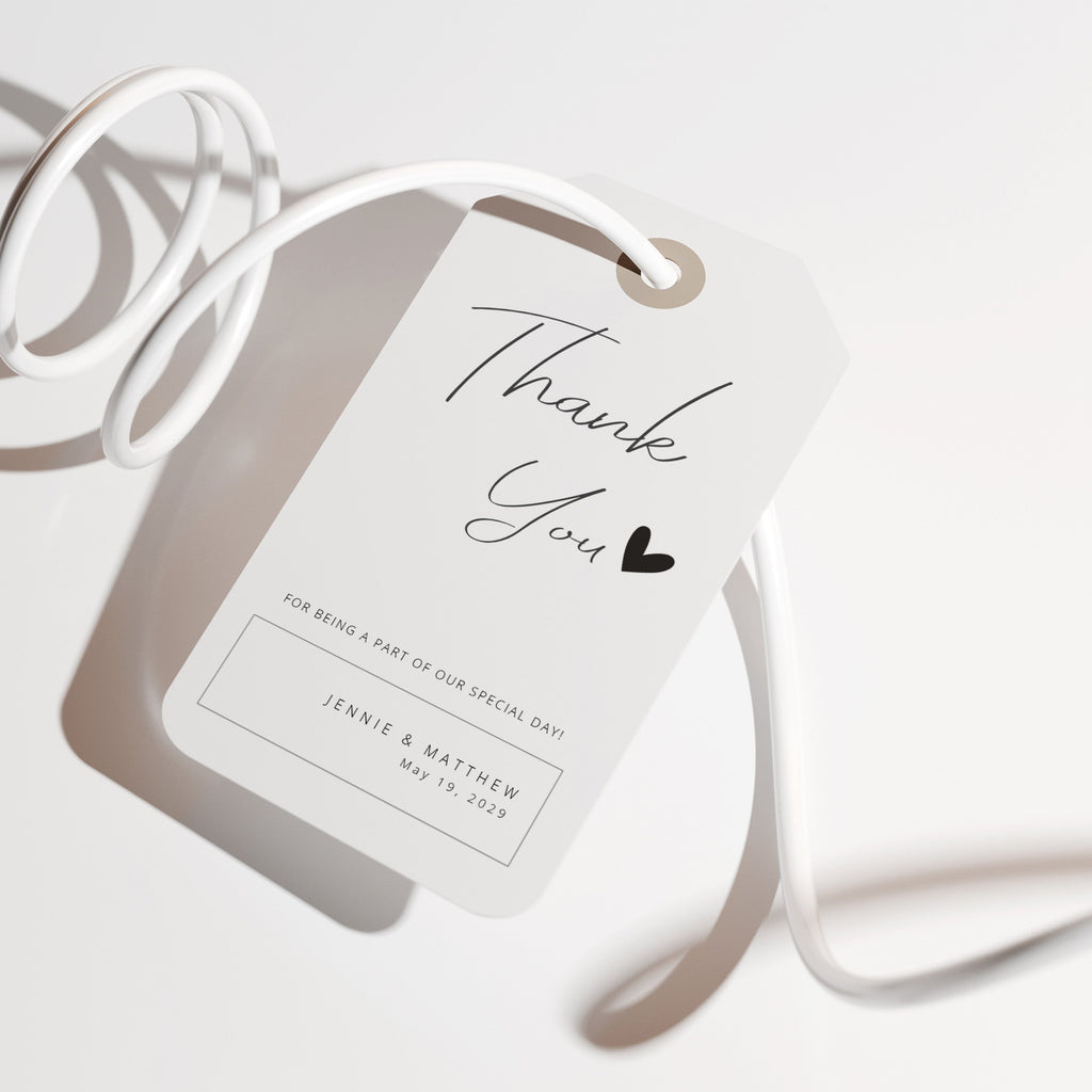 Handwritten script thank you favor tag with a minimal heart detail on a clean white background