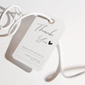 Handwritten script thank you favor tag with a minimal heart detail on a clean white background