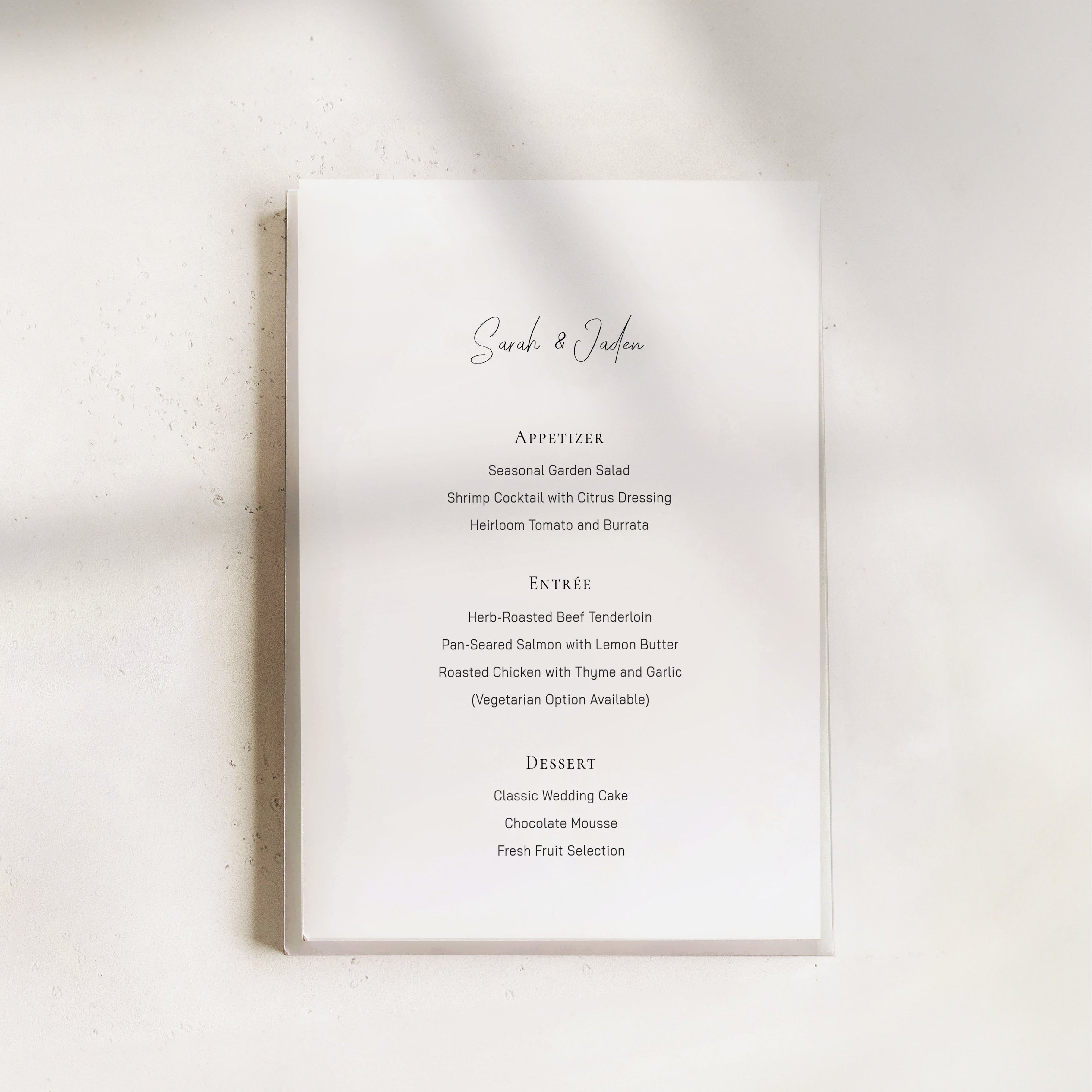 Minimal wedding menu design with centered typography, featuring a clean white card layout, refined serif text, and a softly lit neutral background, styled for an elegant modern wedding table
